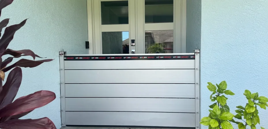 Door flood barrier: Flood Smart panels stacked in side tracks in front of glass double entry doors